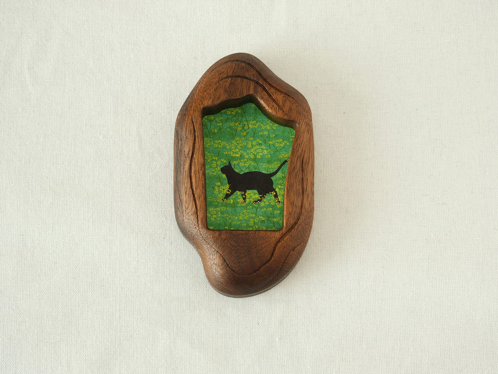 Front view of the Irregular Organic handmade solid wood art frame, featuring a charming illustration of a black cat walking through a field of yellow flowers.