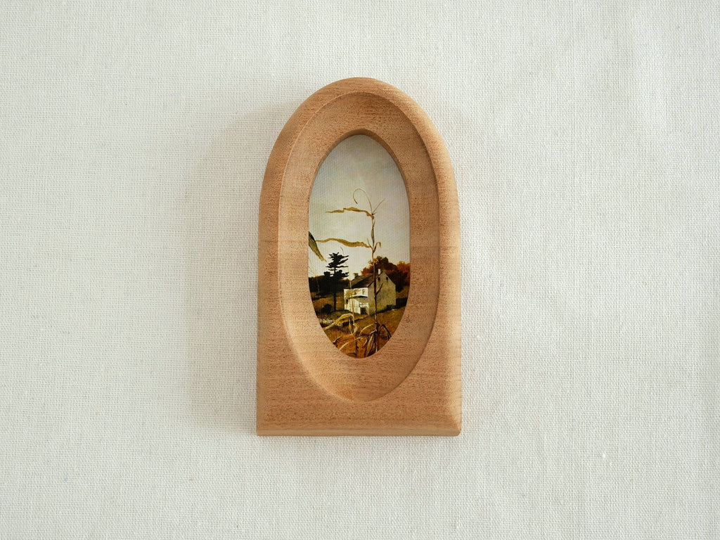 Front view of an elegant arched wood art frame, featuring a portal-like silhouette and smooth hand-sculpted finish.