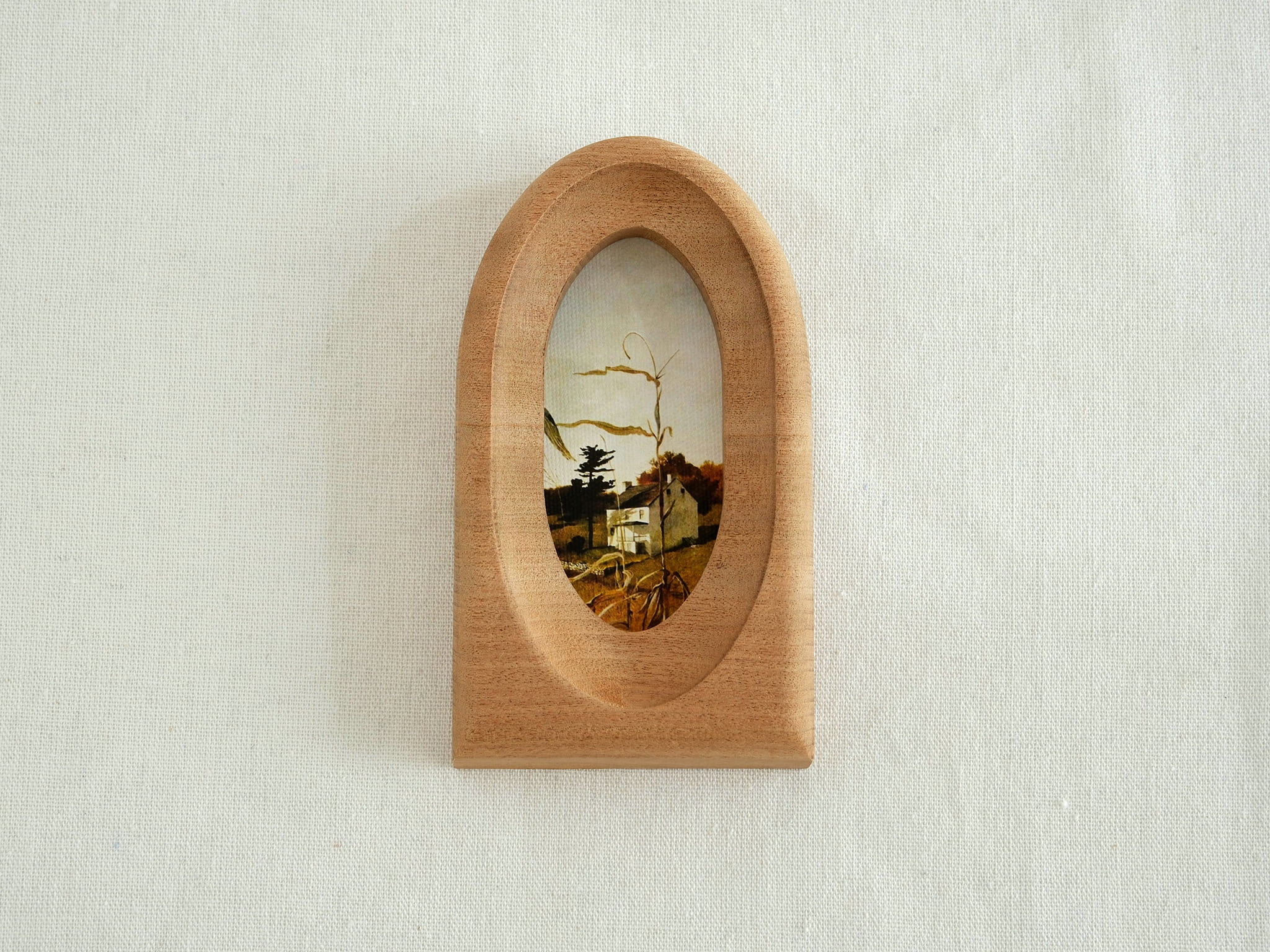 Front view of an elegant arched wood art frame, featuring a portal-like silhouette and smooth hand-sculpted finish.