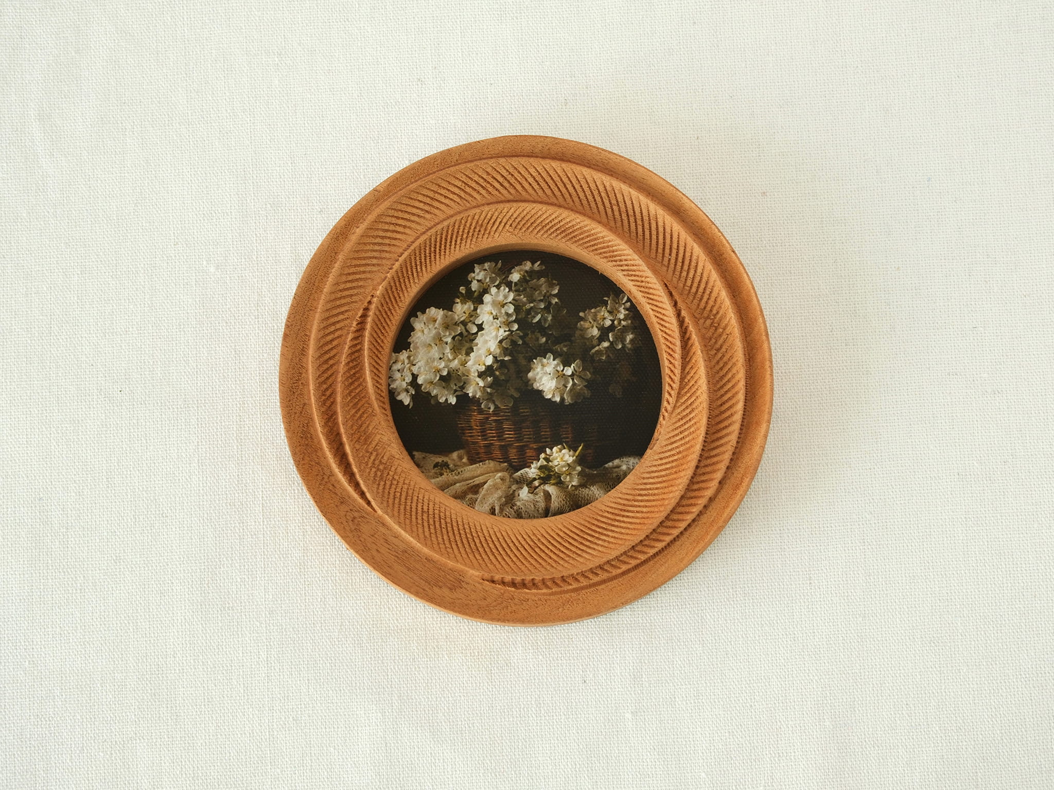 Front view of a round blooming flower shape wood frame, featuring radiant hand-carved petals and warm Sapele grain.