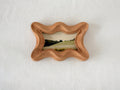 Front view of a rippled wave wood frame, featuring fluid organic edges and a hand-sculpted sculptural silhouette.