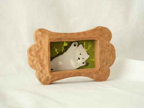 Side-angled view of the bone-shaped wood frame, showcasing its thick profile and hand-chiselled texture on a white backdrop.