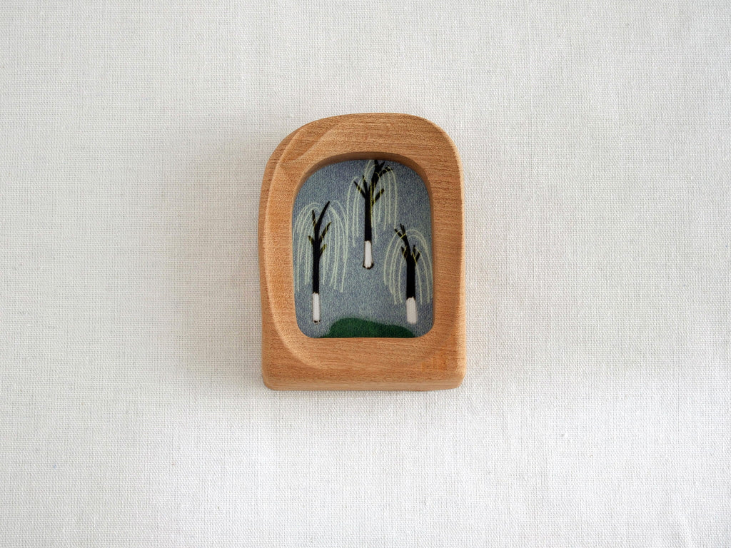 Front view of a soft arched wood frame, featuring a wide organic silhouette and smooth hand-sculpted texture.