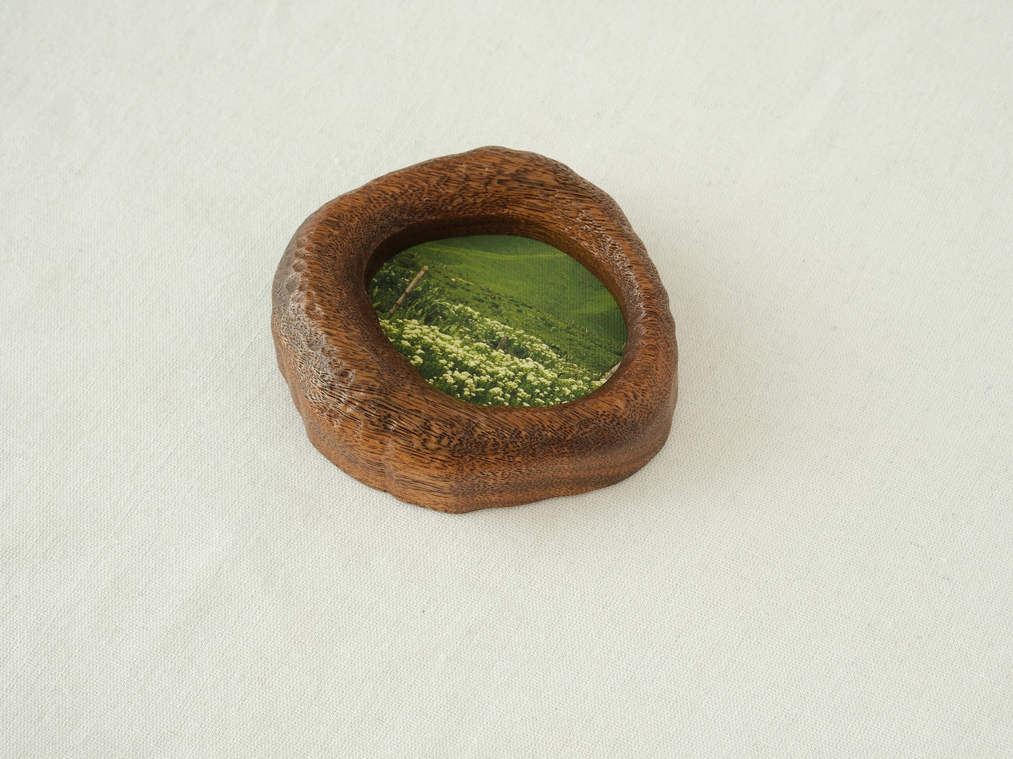 A close-up side view of the lake-shaped organic wood frame, showcasing the rustic hand-carved textures and the natural thickness of the solid timber.