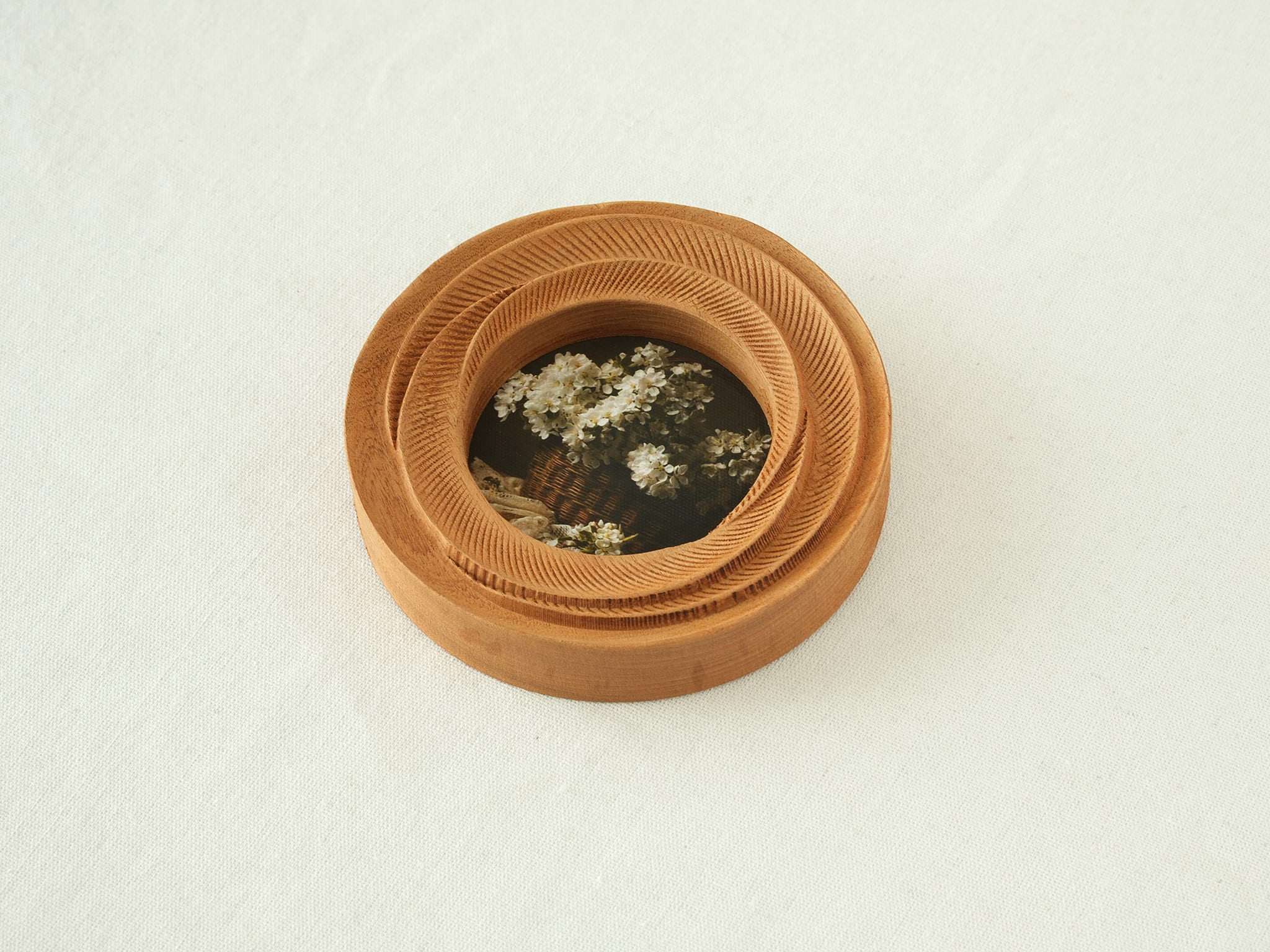 High-angled view of the round flower frame, showing its three-tier stepped design and detailed hand-carved textures.