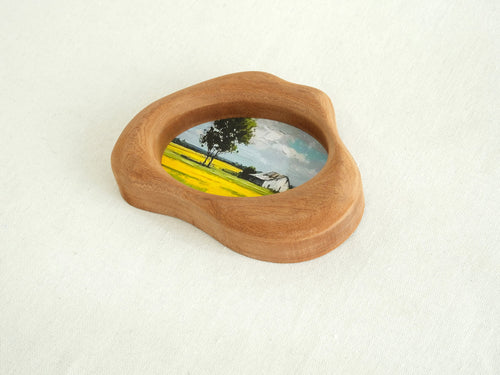 An oblique, high-angle view of the cloud-shaped solid wood frame, showcasing its sculptural depth and the perfectly smooth, hand-sculpted organic curves. The natural wood grain flows continuously across the tactile surface, emphasizing the "Moderno Organico" aesthetic.