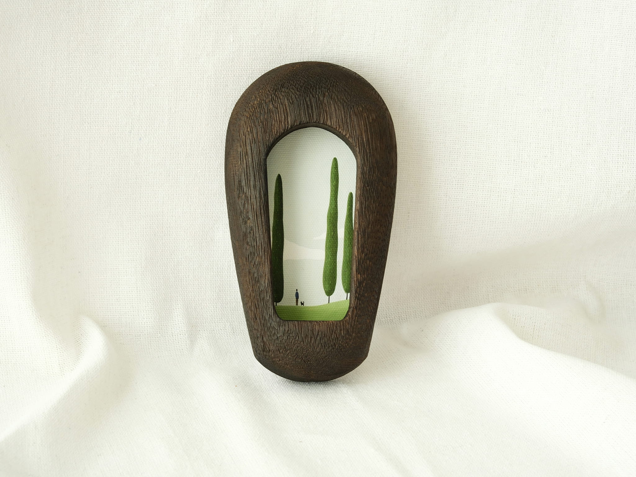 The black arched wood frame leaning against a white fabric backdrop, showcasing its modern minimalist design.