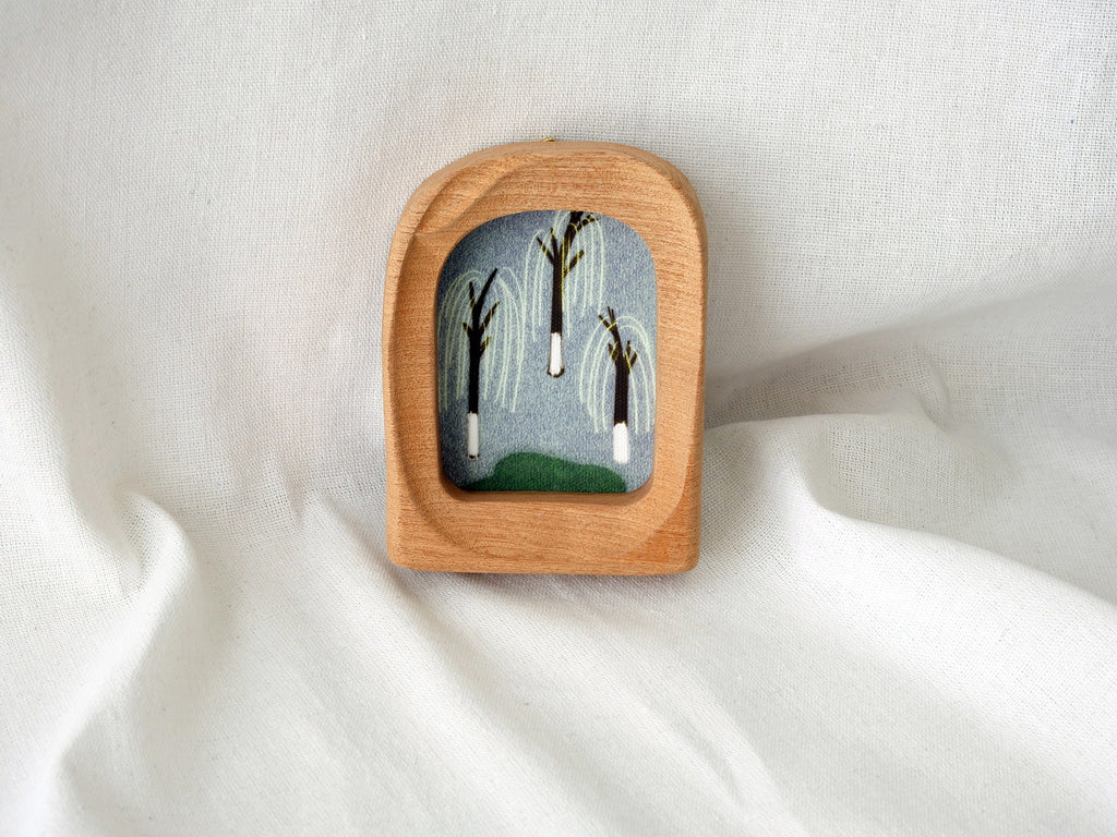 The soft arched wood frame leaning against a soft white draped background, creating a cozy and modern aesthetic.