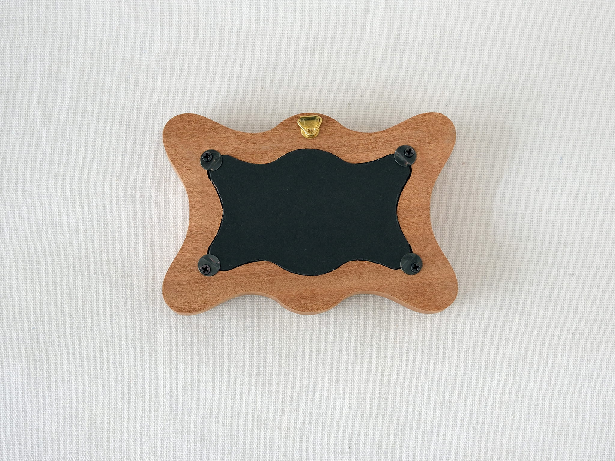 Back view of the rippled wave frame, showing the wall hanger and four secure swivel tabs for easy art replacement.