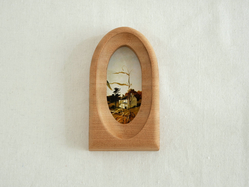 Front view of an elegant arched wood art frame, featuring a portal-like silhouette and smooth hand-sculpted finish.
