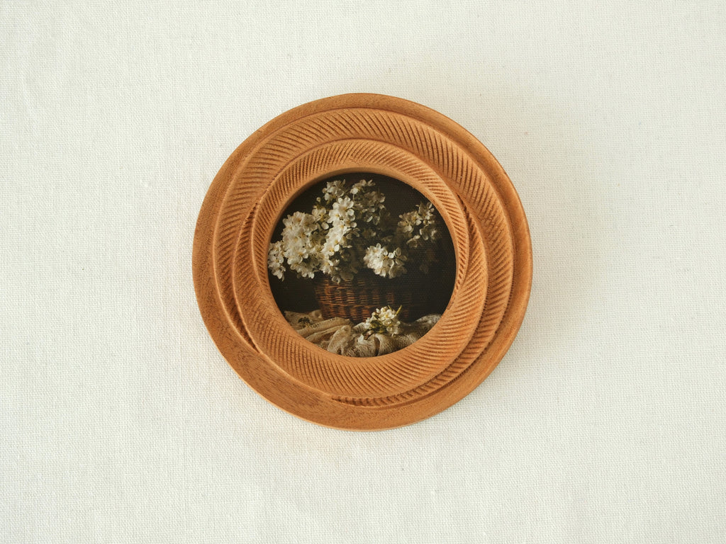 Front view of a round blooming flower shape wood frame, featuring radiant hand-carved petals and warm Sapele grain.