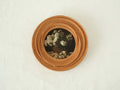 Front view of a round blooming flower shape wood frame, featuring radiant hand-carved petals and warm Sapele grain.