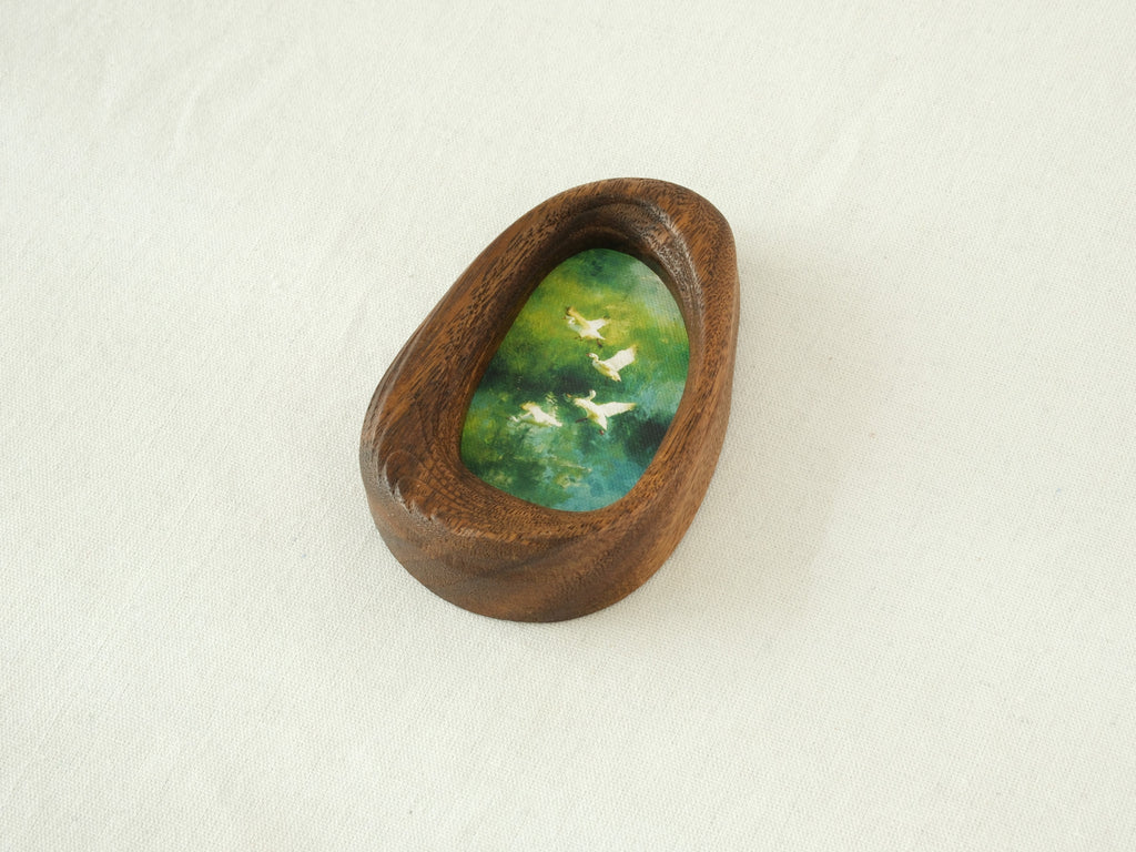 Side view of the Waterdrop handmade solid wood art frame, showcasing the thick pebble-like profile, smooth hand-polished edges, and the depth of the forest birds artwork.