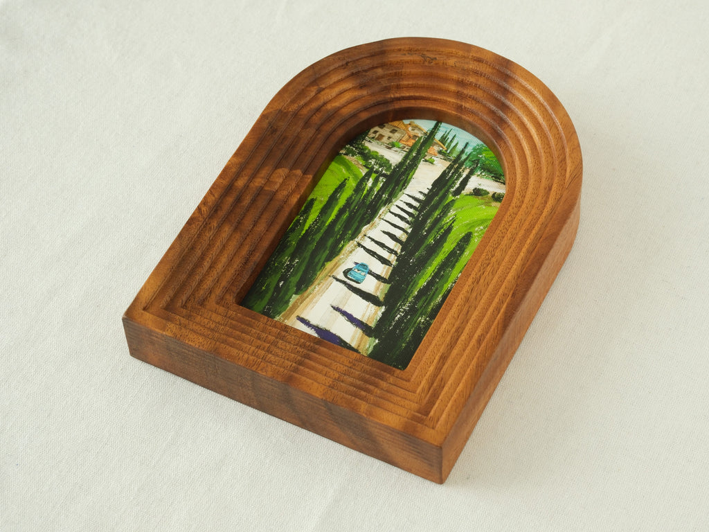 A high-angle three-quarter view from the right, showcasing the unique arched top and the multi-layered stepped wood contours of the solid timber frame.
