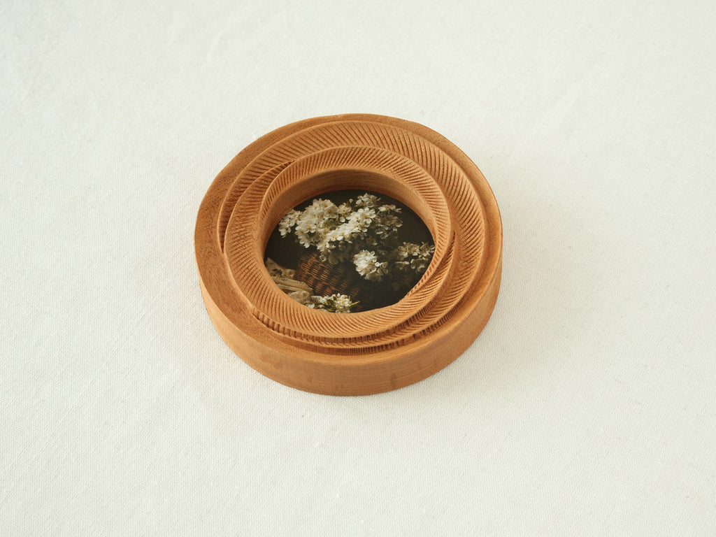 High-angled view of the round flower frame, showing its three-tier stepped design and detailed hand-carved textures.