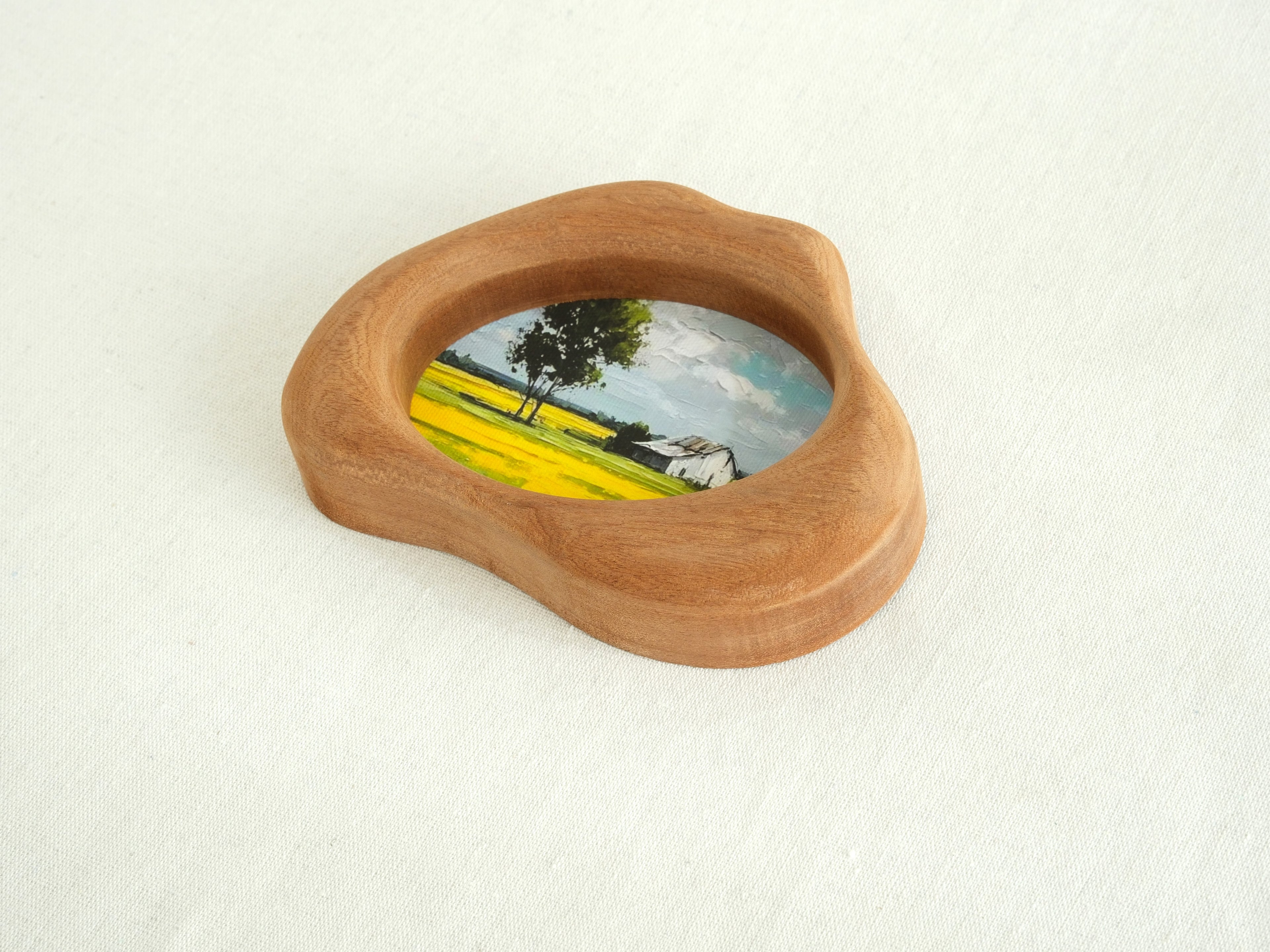 An oblique, high-angle view of the cloud-shaped solid wood frame, showcasing its sculptural depth and the perfectly smooth, hand-sculpted organic curves. The natural wood grain flows continuously across the tactile surface, emphasizing the "Moderno Organico" aesthetic.