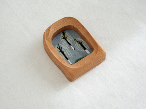 Side angle of the soft arched wood frame, emphasizing its smooth, hand-carved organic curves and warm grain.