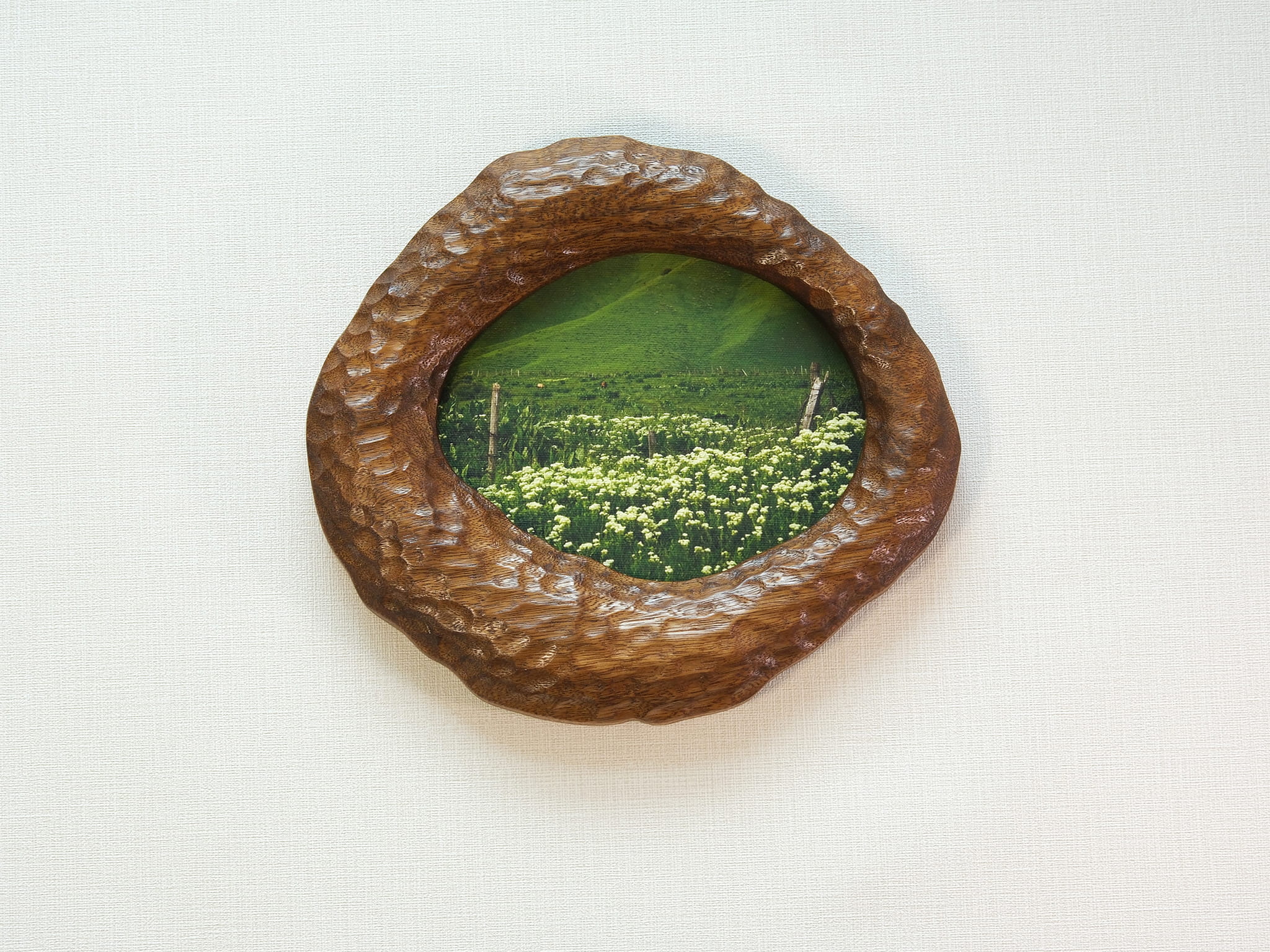 Large walnut wood wall art picture frame with green landscape artwork, front view.