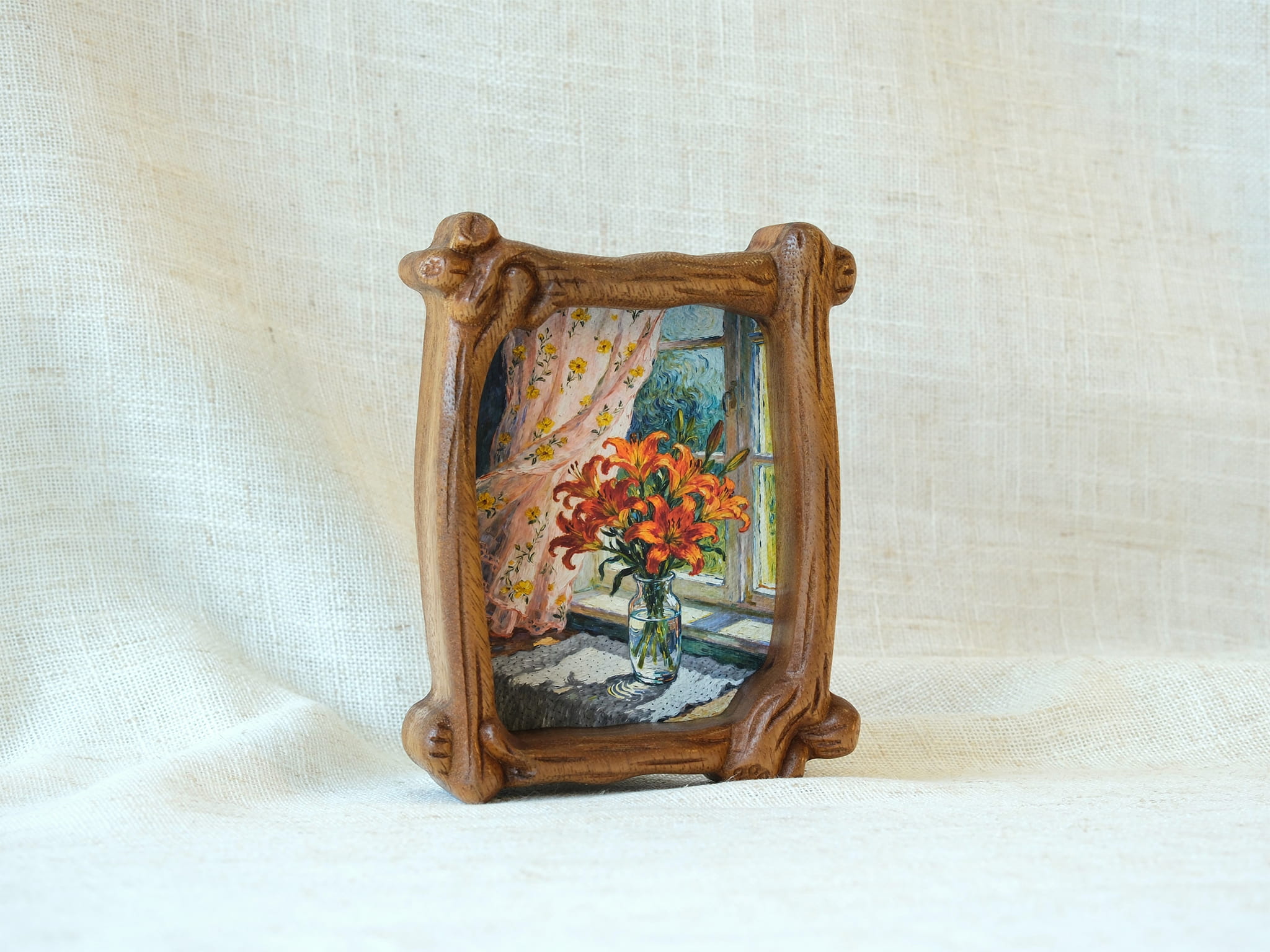 Handcrafted organic shaped solid wood picture frame with a natural grain finish, displayed on a white fabric background as a tabletop decorative art piece.