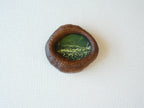 Front view of the lake-shaped organic solid wood frame, featuring a serene landscape painting of a green meadow filled with white wildflowers.