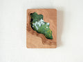 Large handmade solid wood wall art picture frame with flowing stream-shaped cutout and floral meadow artwork, front view.