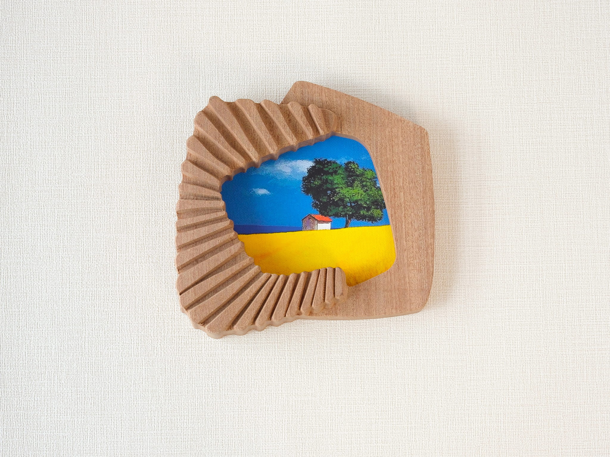Handmade solid wood wall art picture frame with accordion-inspired shape and landscape artwork, front view.