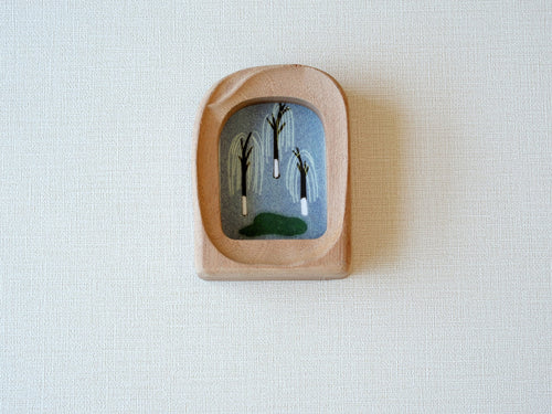 Front view of a soft arched wood frame, featuring a wide organic silhouette and smooth hand-sculpted texture.
