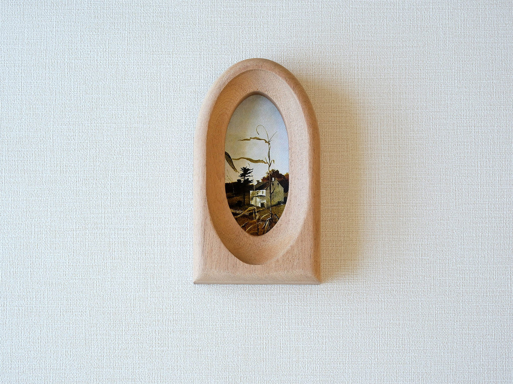 Front view of an elegant arched wood art frame, featuring a portal-like silhouette and smooth hand-sculpted finish.