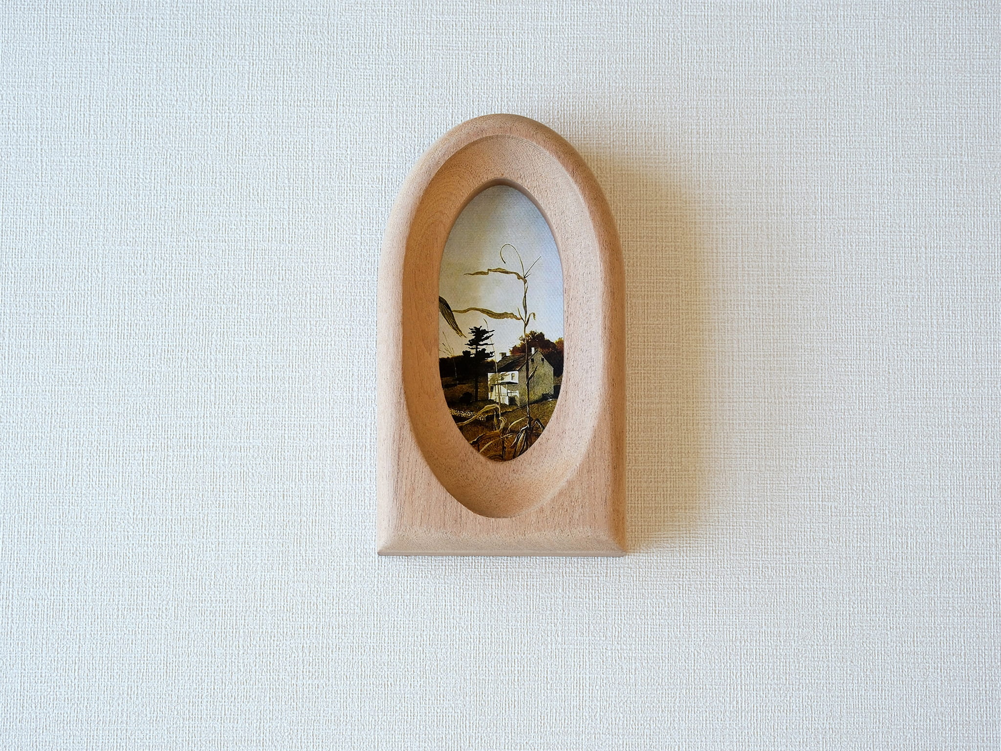 Front view of an elegant arched wood art frame, featuring a portal-like silhouette and smooth hand-sculpted finish.