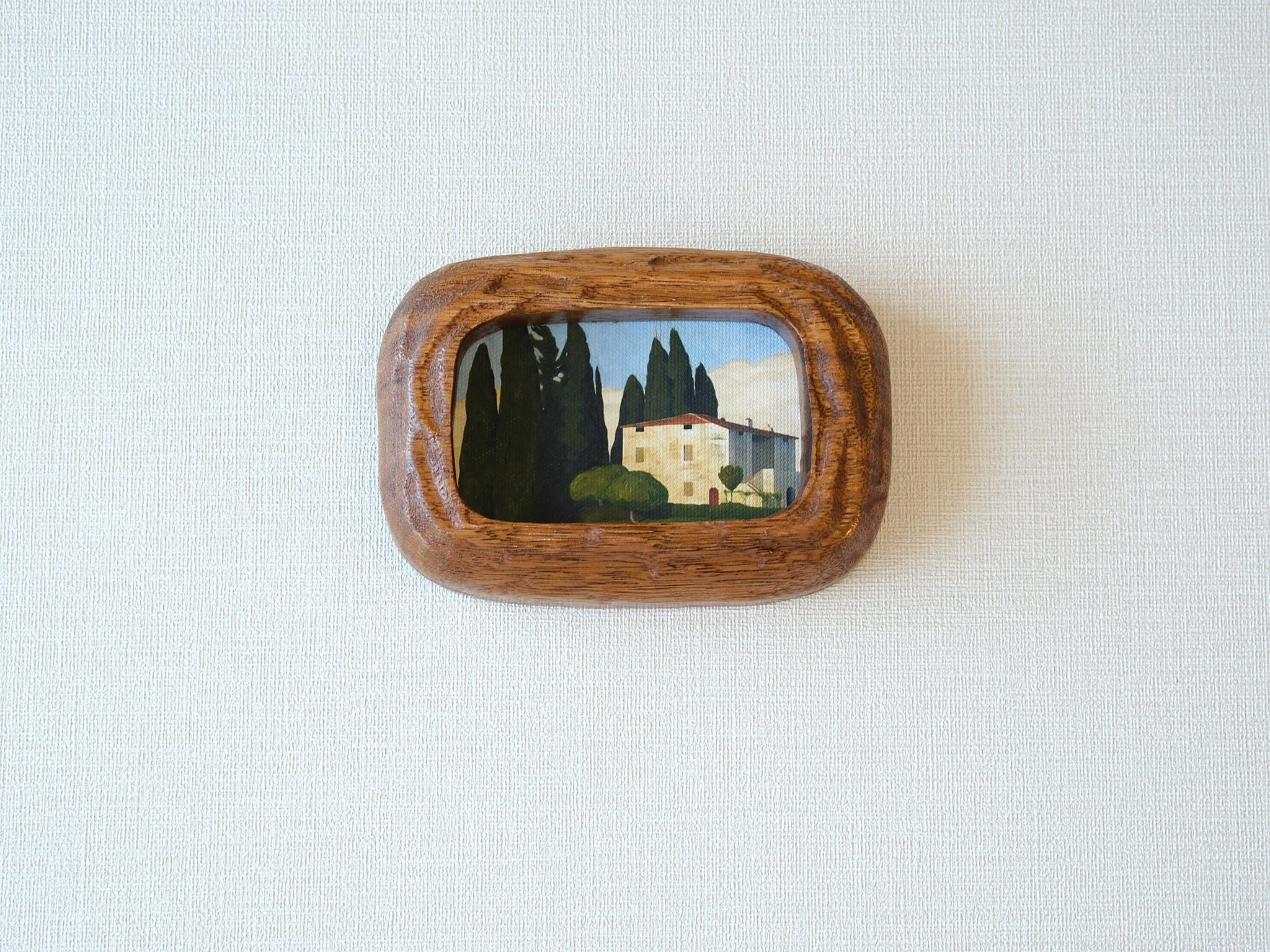 Handcrafted South American walnut wood picture frame with organic chunky shape and a landscape art print.