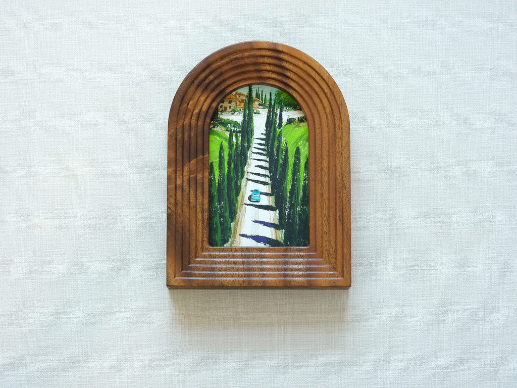 Front view of the arched solid wood frame "Tuscany," featuring a handcrafted stepped border and an oil-style painting of a cypress-lined road leading to an Italian villa.