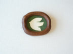 Front view of a Fomjia handcrafted organic-shaped wood frame featuring a minimalist cream dove illustration on a forest green canvas background.