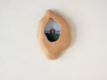 Handmade solid wood wall hanging art picture frame with red house artwork, organic shape front view.
