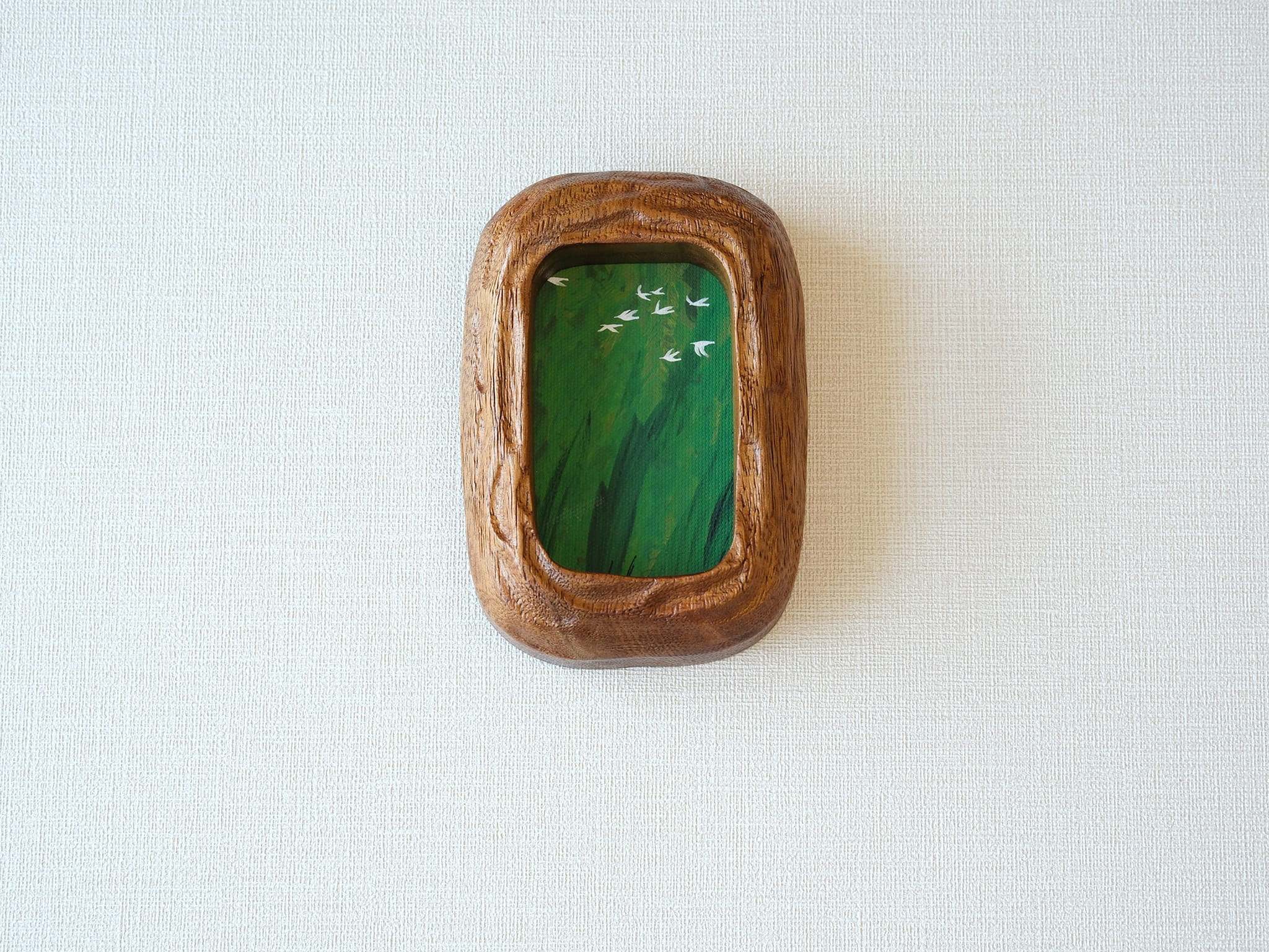 Front view of the Rounded Rectangle handmade solid wood art frame in a vertical orientation, featuring a painting of white birds flying over a dense green forest.