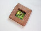 Large handmade solid wood picture frame with green forest artwork, high-angle side view.