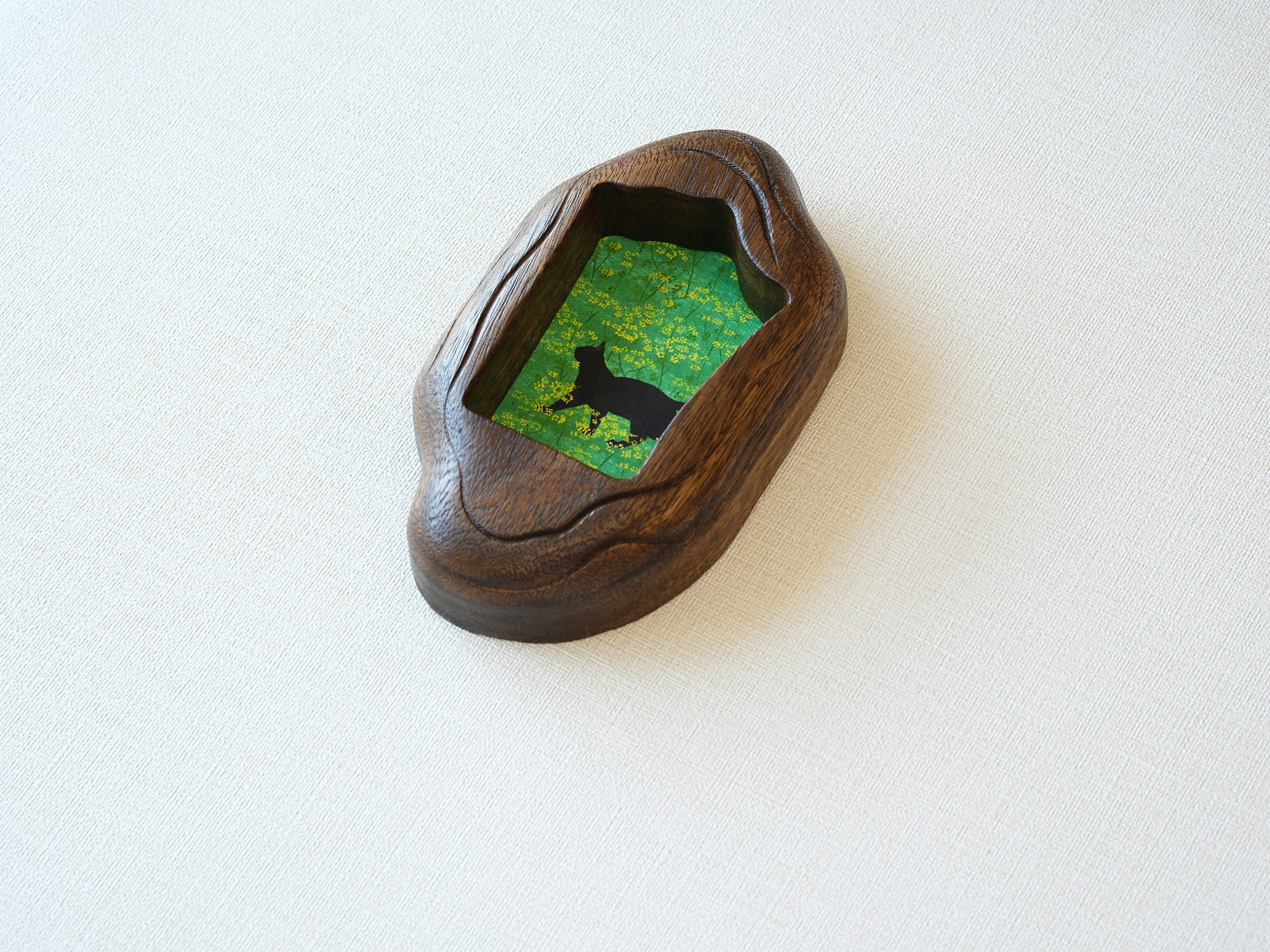 An angled overhead view of the irregular organic solid wood frame, highlighting its thick, flowing contours and the handcrafted grooves on the timber surface.