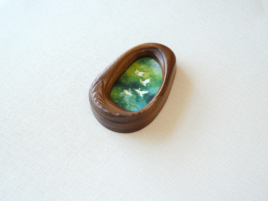 Side view of the Waterdrop handmade solid wood art frame, showcasing the thick pebble-like profile, smooth hand-polished edges, and the depth of the forest birds artwork.