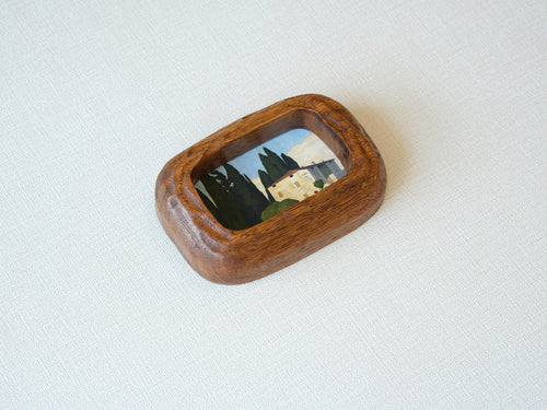Side angle of a chunky South American walnut frame, showcasing the deep wood texture and handcrafted curved edges.