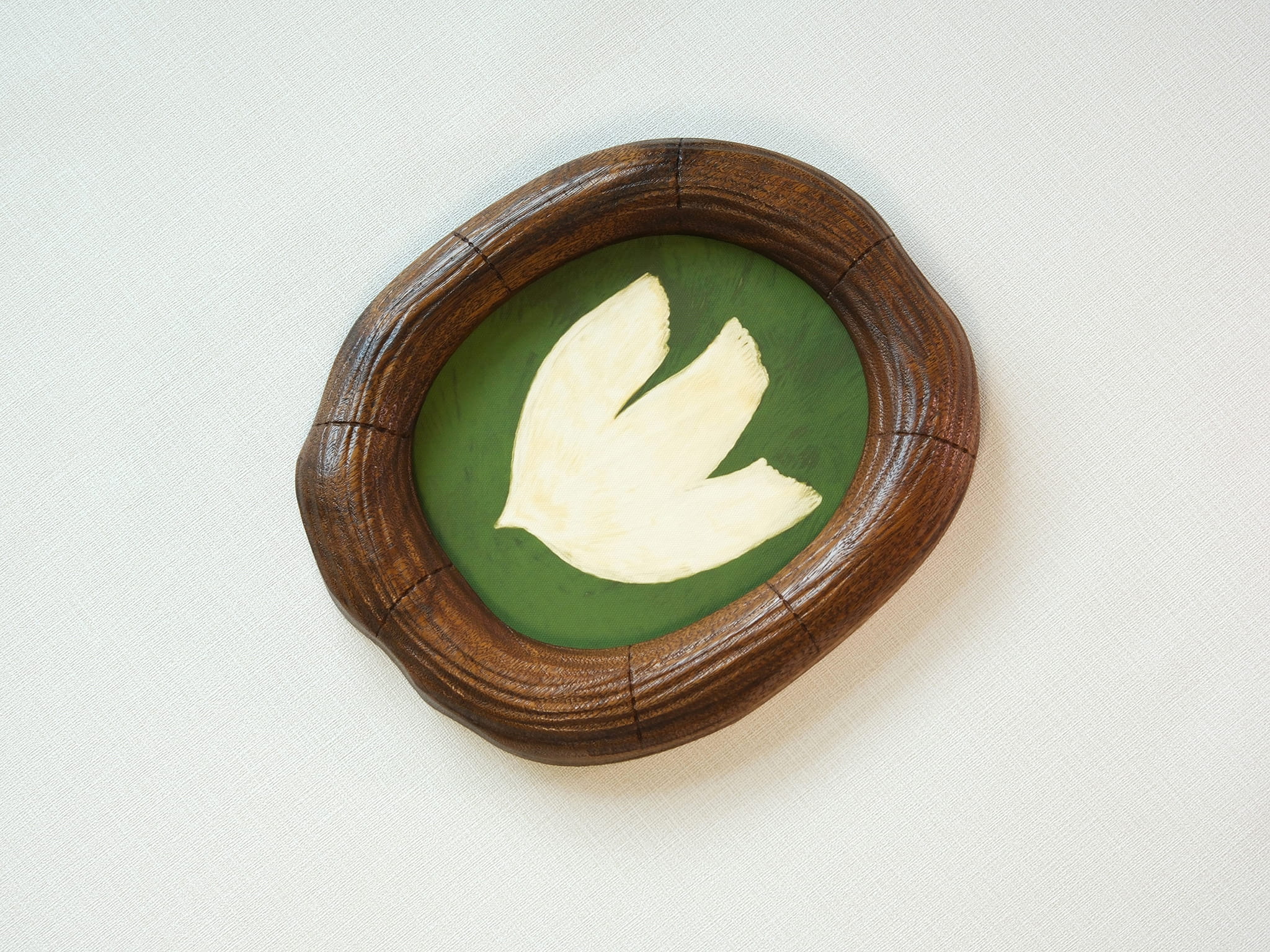 Large walnut wood wall art picture frame with dove artwork, high-angle side view.