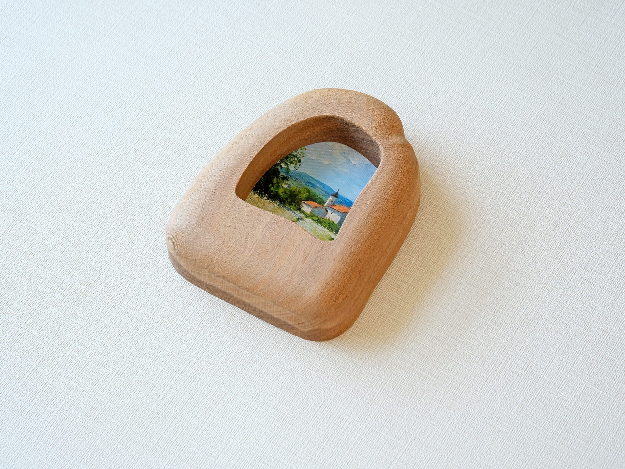 Side view of the house-shaped wood frame, highlighting its smooth, hand-carved organic edges and thick solid Sapele.