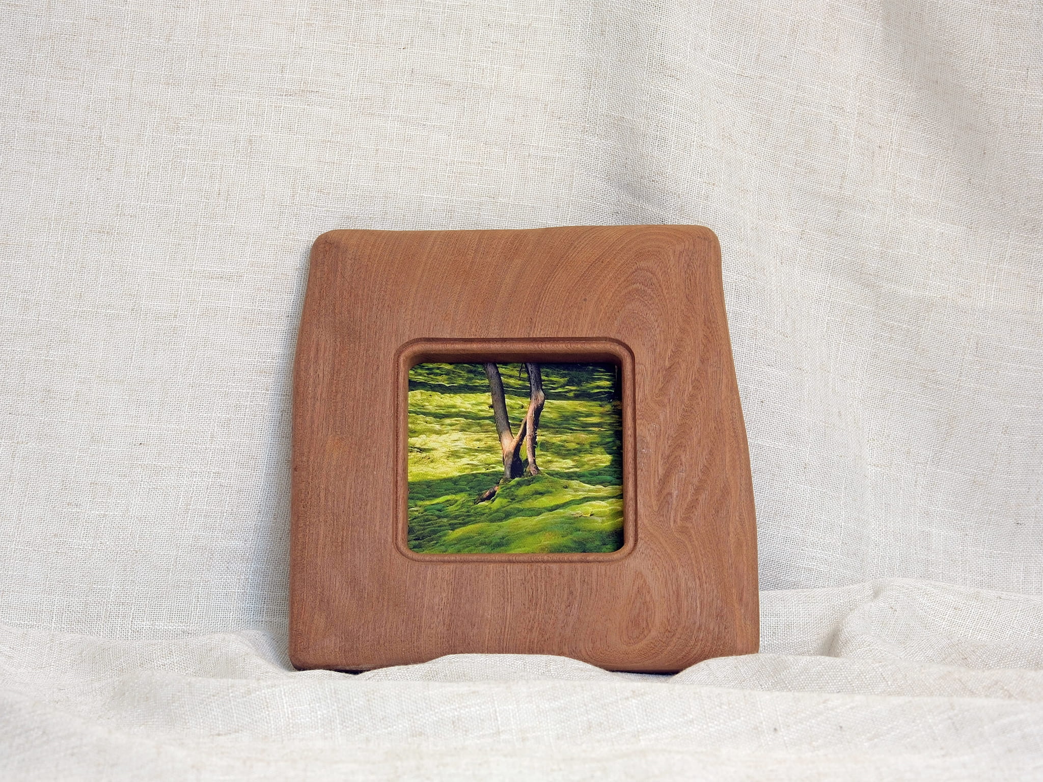 Large handmade solid wood picture frame with green forest artwork, standing display.
