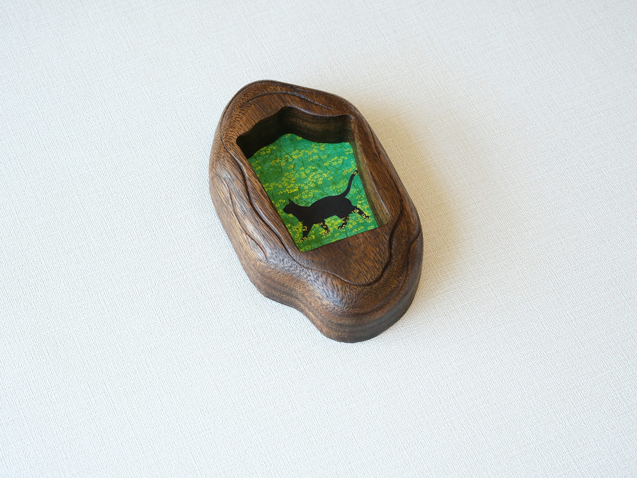 A perspective side view of the irregular organic wood frame, showcasing the rich, dark timber grain and the unique, fluid hand-carved edges.