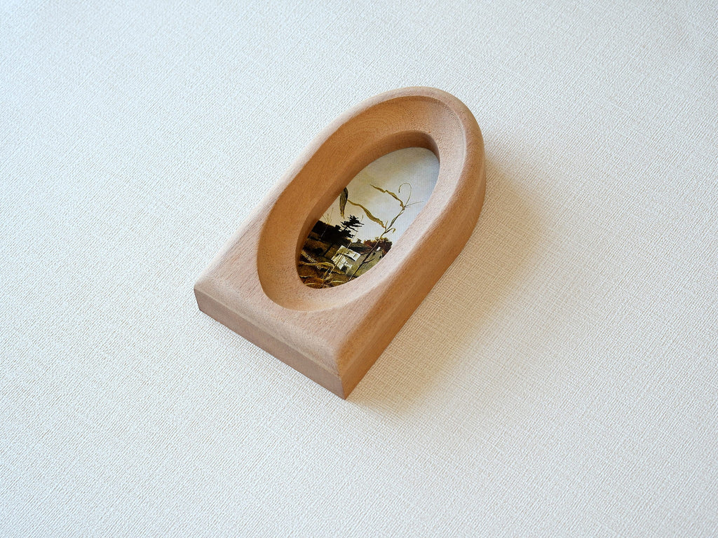 Alternative side view of the arched wood frame, emphasizing its smooth curved top and solid architectural base.