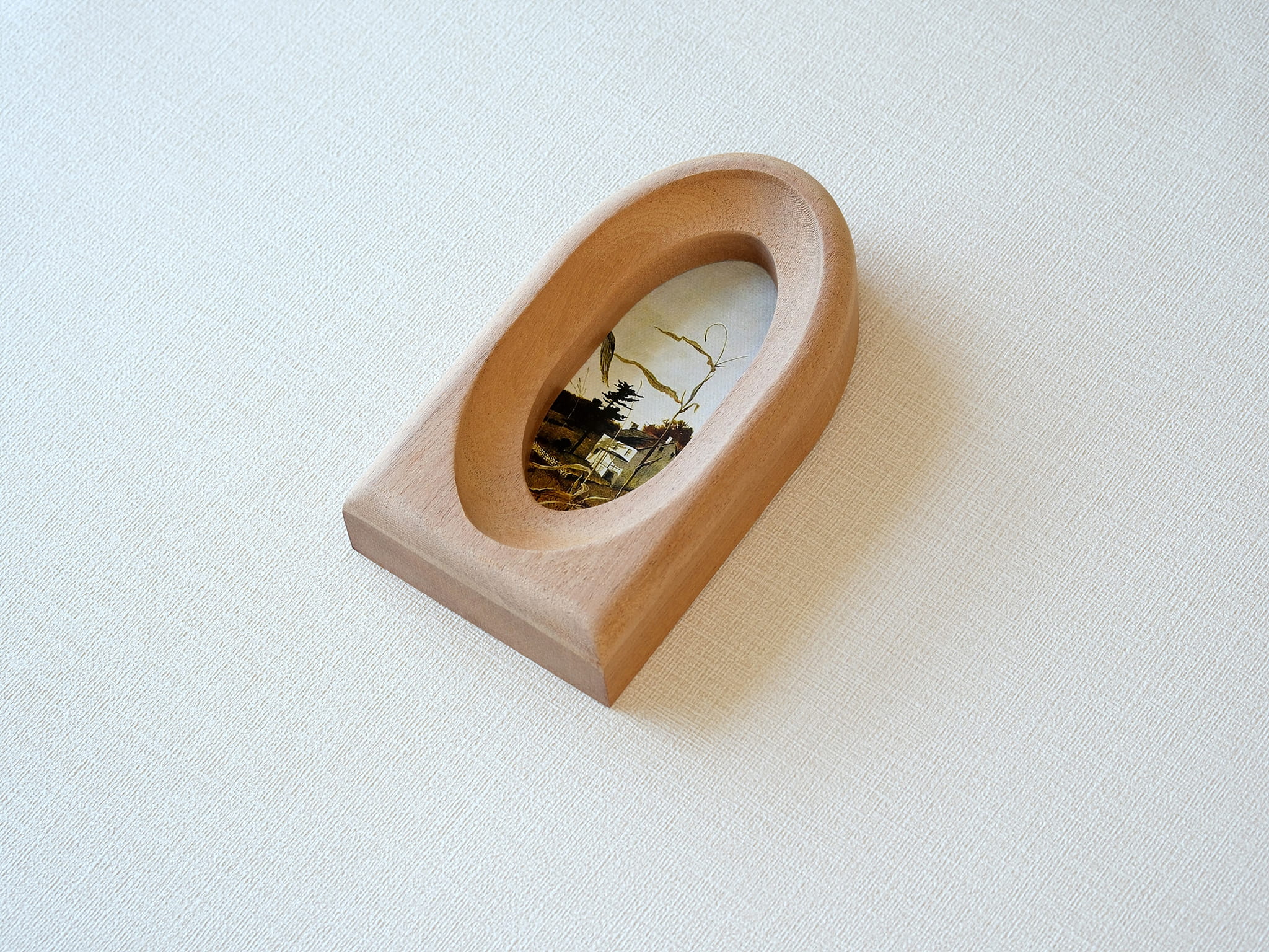 Alternative side view of the arched wood frame, emphasizing its smooth curved top and solid architectural base.