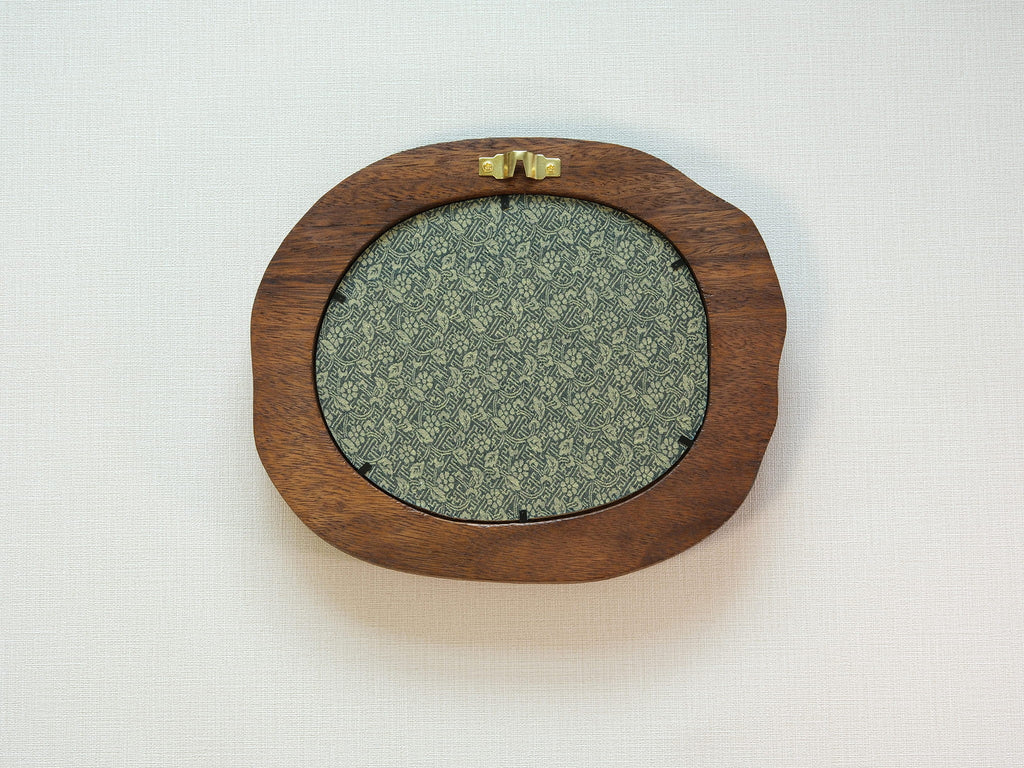 Large walnut wood picture frame back view with wall hanger and patterned backing panel.