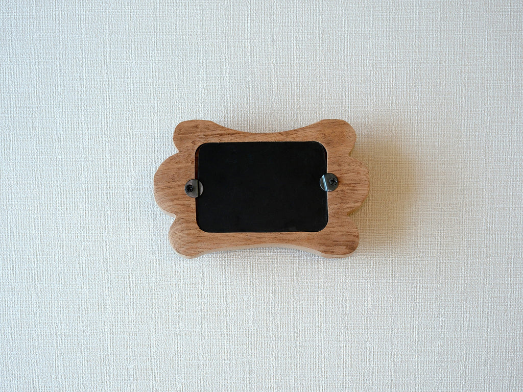 Back view of the bone-shaped frame, showing the clean wood finish and two swivel tabs for easy desktop photo display.