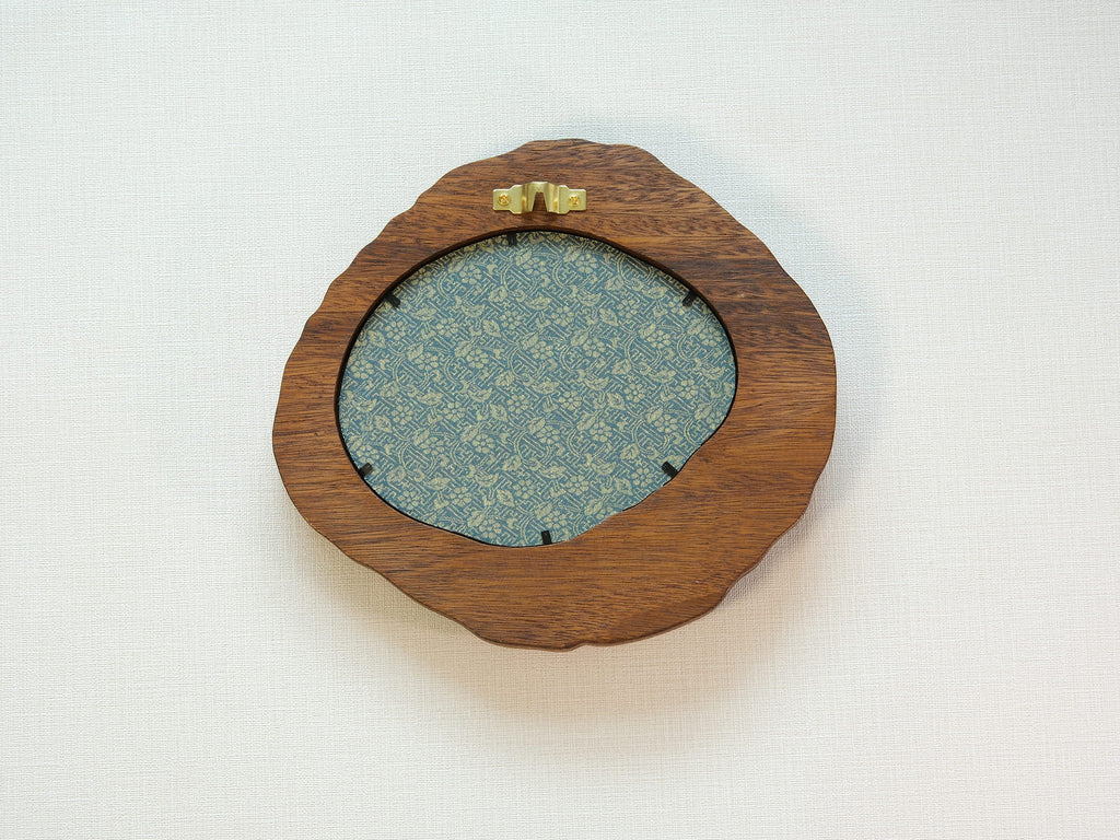 Large walnut wood picture frame back view with wall hanger and patterned backing panel.