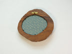 Large walnut wood picture frame back view with wall hanger and patterned backing panel.