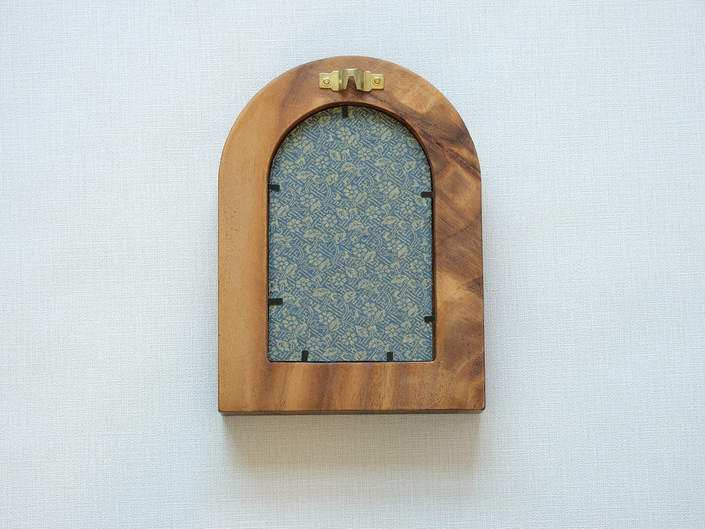 Rear view of the arched "Tuscany" solid wood frame, showing the integrated gold wall hanger and the elegant blue and gold floral textile backing that protects the artwork.
