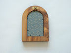 Rear view of the arched "Tuscany" solid wood frame, showing the integrated gold wall hanger and the elegant blue and gold floral textile backing that protects the artwork.